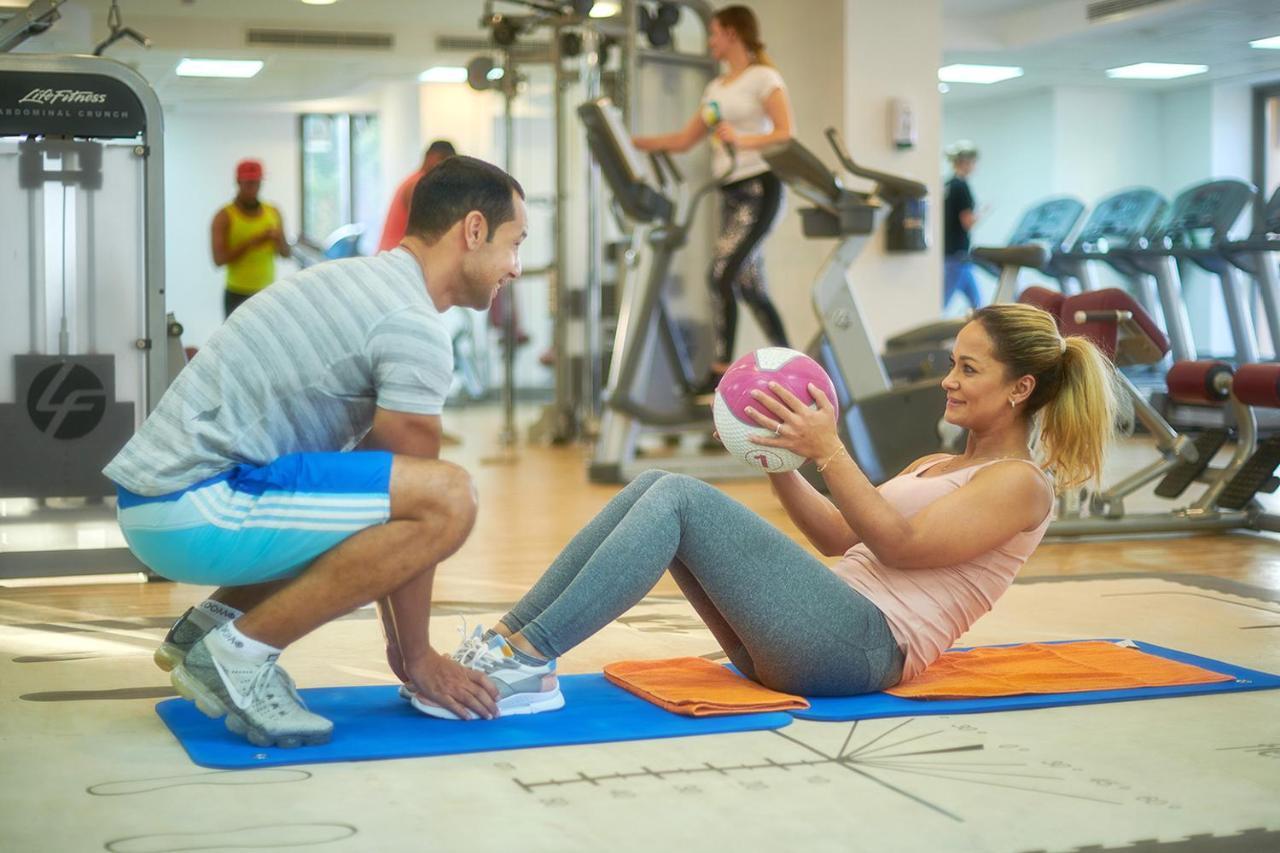 Bahi Ajman Palace Hotel Bagian luar foto Personal trainer assisting a woman with sit-ups