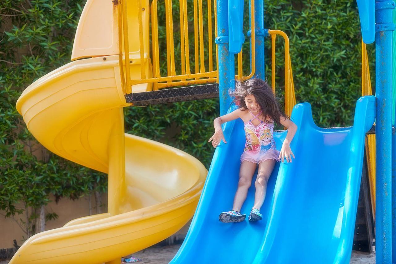 Bahi Ajman Palace Hotel Bagian luar foto A child on a slide